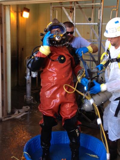 A diver decontaminates after a dive in a sewer pump station to remove a clog
